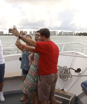 A group of people take a selfie during their miami boat tours.